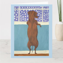Tarjeta Dachshund en la ventana viendo nevar