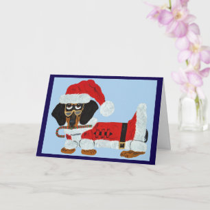 Tarjeta Dachshund negro y marrón de Santa con un bastón de