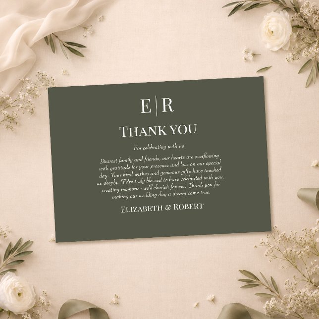 Tarjeta de agradecimiento de boda con monograma de (Dark Olive Monogram Wedding Thank You Card on a table with with flowers and wedding decor)