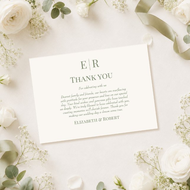 Tarjeta de agradecimiento de boda con monograma de (Olive Monogram Wedding Thank You Card on a table with white roses and wedding decor)