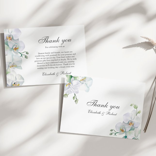 Tarjeta de agradecimiento de boda de orquídea blan (Elegant White Orchid Wedding Thank You Card on a sunny elegant white table.)