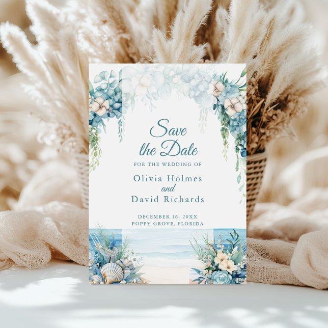 Tarjeta de Anuncio de Boda de Arco Floral Azul Boh (Boho Blue Floral Arch Beach Save the Date Card on a sunny table in front of white pampas grass)