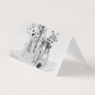Tarjeta de cuatro botellas y flores blancas