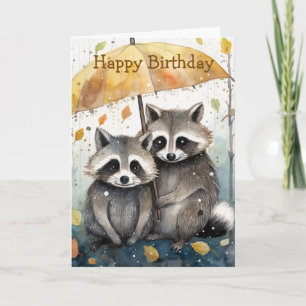 Tarjeta de cumpleaños de mapaches lindos en la llu