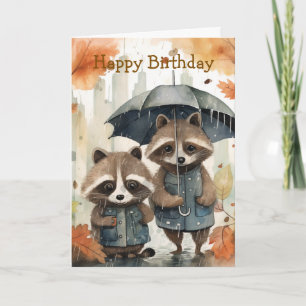 Tarjeta de cumpleaños de mapaches lindos en la llu