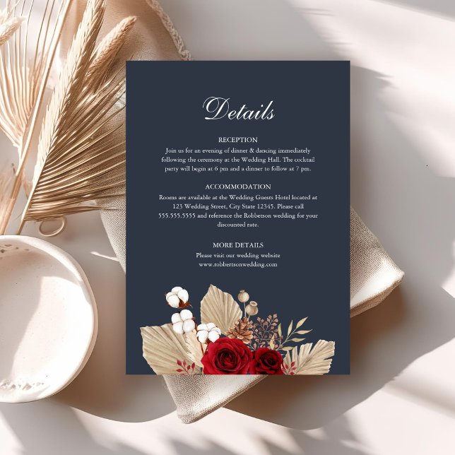 Tarjeta de Detalles de Boda de Rosas Borgoña Azul  (Midnight Blue Burgundy Roses Wedding Details Card on a boho table with dry palm leaf.)