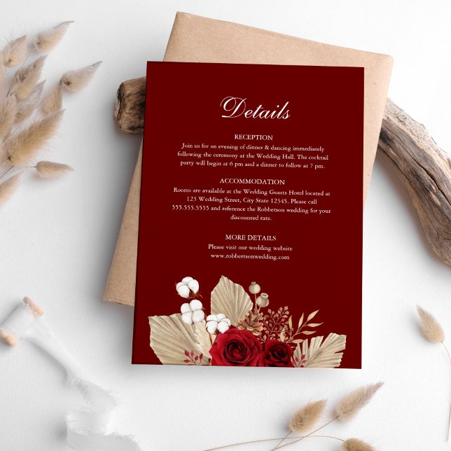 Tarjeta de detalles de la boda del jardín del Rosa (Burgundy Rose Garden Wedding Details Card on table surrounded with pampas grass.)