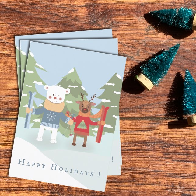 Tarjeta de festividad de oso polar y amigo reno (Polar bear and reindeer kid Holiday cards laying flat on a desk .)