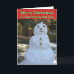 Tarjeta de hijo de navidades Snowman<br><div class="desc">Feliz Navidad a nuestro Maravilloso hijo está escrito en el frente de la tarjeta de felicitación de los Navidades en texto verde sobre fondo rojo. Alegre Snowman colgando en el bosque con rocas para los ojos, nariz y botones, ramas para la sonrisa y los brazos, y un gorra de mariscos...</div>