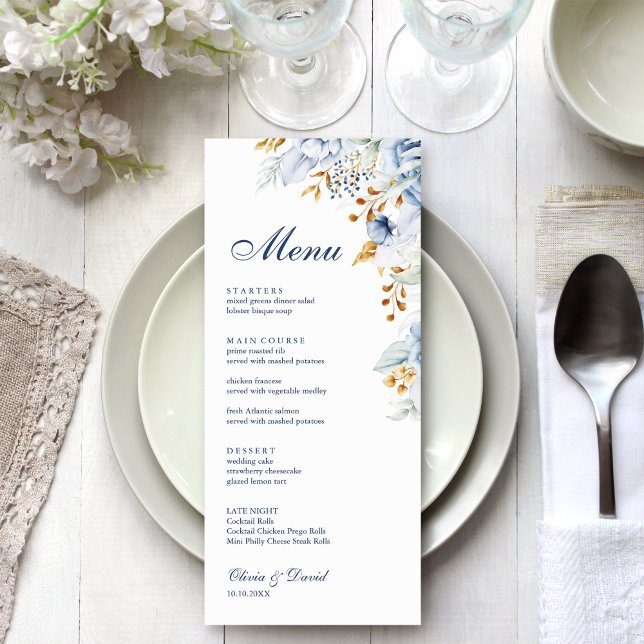 Tarjeta de menú Boda floral azul y dorado moderno (Modern Blue and Gold Floral Wedding Menu Card on an elegant wedding table with white flowers.)