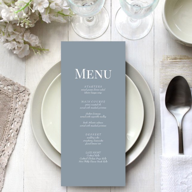Tarjeta de menú de boda con monograma azul polvori (Minimalist Dusty Blue Monogram Wedding Menu Card on a beautiful white and silver wedding table.)