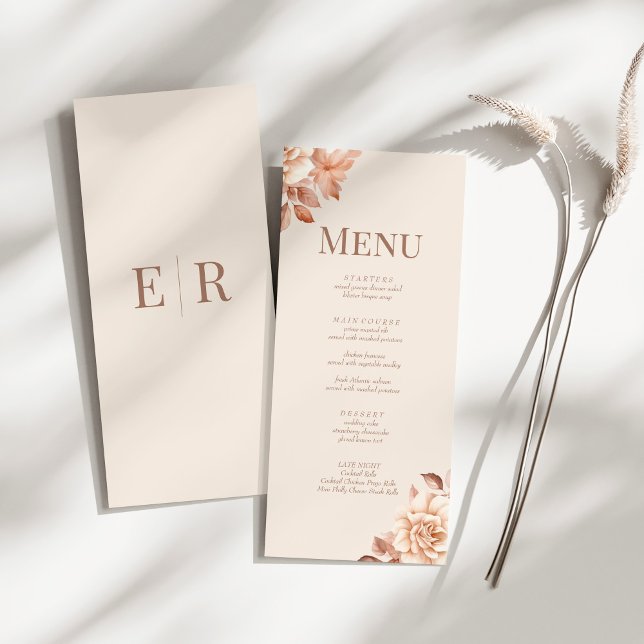 Tarjeta de menú de boda con monograma en beige son (Modern Rose Gold Floral Monogram Wedding Menu Card on a sunny white table.)
