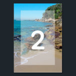 Tarjeta De Mesa Boda Rocky Beach<br><div class="desc">Este diseño de playa cuenta con una costa rocosa. El pintoresco entorno combina la vegetación, el océano azul, la costa rocosa y la arena dorada. La redacción está elegantemente enmarcada con un simple fondo blanco opaco de borde. Este es el destino de playa perfecto para el diseño de bodas, ideal...</div>