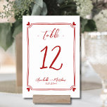 Tarjeta De Mesa Boda rojo caprichoso<br><div class="desc">Elegante Mano Dibujó El Número De La Mesa Del Boda. Esta adorable tarjeta numérica de mesa presenta un marco sutil, dibujado a mano, con corazones negros en cada esquina, creando un diseño divertido y elegante que rodea suavemente el número de la mesa. La mezcla de guiones y tipos de letra...</div>