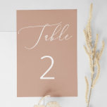 Tarjeta De Mesa Delicado Boda Minimalista de color beige oscuro<br><div class="desc">Esta elegante tarjeta numero de mesa de boda presenta un suave fondo de color melocotón, acentuado por un delicado guión blanco y una numeración limpia. El suave tono marrón rosado le da un aspecto romántico y moderno, ideal para bodas de primavera o otoño, paletas de tonificación rubia o celebraciones minimalistas....</div>