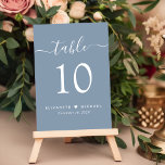 Tarjeta De Mesa Moda Script Dusty Blue Wedding Recepción<br><div class="desc">Moda polvorienta señal de la mesa de la recepción nupcial azul con "mesa" en un moderno y elegante guión blanco con toques, el número de la mesa en una elegante tipografía de serif blanca, sus nombres unidos por un corazón y la fecha de recepción. Cree cada número de tabla individualmente...</div>
