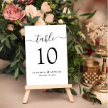 Tarjeta De Mesa Recepción de boda con guión de moda<br><div class="desc">Señal de número de la mesa de la recepción de bodas de moda con "mesa" en un guión elegante de caligrafía con toques, el número de la mesa en una tipografía serif elegante, sus nombres unidos por un corazón y la fecha de recepción. Cree cada signo de número de tabla...</div>