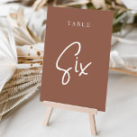 Tarjeta De Mesa Tabla SIX con guiones de mano oxidada<br><div class="desc">Las tarjetas de número de tabla simple y de moda en color de tierra rojizo marrón y blanco hacen una declaración elegante en su boda o evento. Las funciones de diseño "table [number]" se encuentran en una mezcla de letras clásicas de sif y manuscritas. El diseño se repite en ambos...</div>