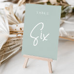 Tarjeta De Mesa Tabla SIX con guiones de mano verde pálido<br><div class="desc">Las tarjetas de número de tabla simples y de moda en verde y blanco Pale Sage hacen una declaración elegante en su boda o evento. Las funciones de diseño "table [number]" se encuentran en una mezcla de letras clásicas de sif y manuscritas. El diseño se repite en ambos lados. Las...</div>