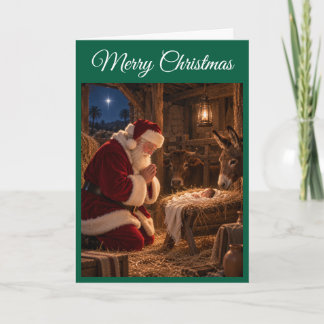 Tarjeta de Navidad de Santa rezando en el pesebre