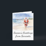 Tarjeta de Navidades Beach Santa Watercolor<br><div class="desc">Esta tarjeta de Navidad muestra a un Santa Claus relajado disfrutando de un largo paseo por la playa. Personalizar esta tarjeta de Navidades para reflejar tu ciudad de playa favorita!</div>