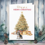 Tarjeta de Navidades beagles de árbol de oro<br><div class="desc">En la parte delantera de esta tarjeta de Navidades, un adorable cachorro Beagle lleva un sombrero de Santa Claus rojo y blanco y se sienta frente a un árbol de vacaciones. El árbol está decorado en oro, y debajo hay paquetes de regalos a juego. El texto dorado y rojo dice...</div>