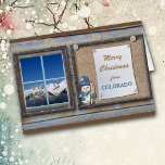 Tarjeta de Navidades del tablero de anuncios Cute<br><div class="desc">Esta linda tarjeta de Navidades de Colorado incluye un tablón de anuncios con tu mensaje, y una imagen de un pequeño muñeco de nieve cargando sus esquís. Al lado del tablero de anuncios hay una ventana que muestra hermosas montañas cubiertas de nieve, majestuosas, contra un cielo azul brillante. El texto...</div>