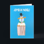 Tarjeta de navidades, francés, pastel con Snowman<br><div class="desc">Una carta de Navidades franceses alegre y luminosa, con un muñeco de nieve decorado y florido sobre un quequito helado, de un collage de papel pintado a mano de Judy Adamson. El saludo delantero, en blanco sobre fondo azul, es "Joyeux Noel!" y el mensaje interior, que se puede cambiar, es,...</div>