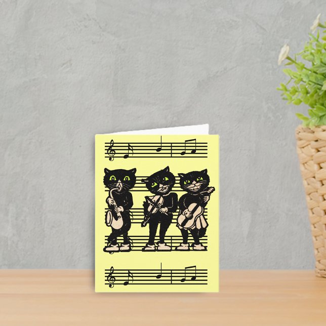 Tarjeta de nota musical de los gatos negros (Three black cat musicians playing instruments on sheet of music on bright yellow notecards.)