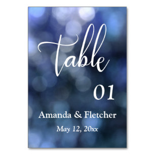 Tarjeta de número de mesa con luz de bokeh azul y 