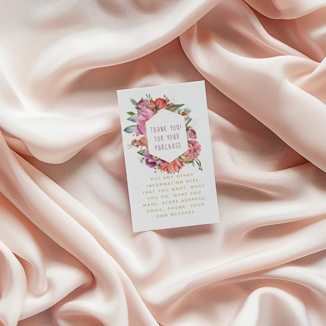 Tarjeta De Recepción Flores y macarrones borde dorado (Floral thank-you card with watercolor flowers and gold text, placed on soft blush fabric background)
