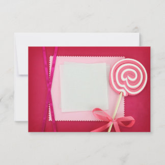 Tarjeta en blanco con lollipop sobre fondo rosa