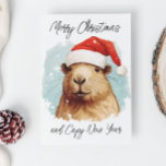 Tarjeta Feliz Navidad Capybara<br><div class="desc">Este diseño se puede personalizar eligiendo la opción Editar diseño. También puede transferir a otros artículos. Póngase en contacto conmigo en colorflowcreations@gmail.com o utilice la opción de chat en la parte superior de la página si desea tener este diseño en otro producto o necesita ayuda con este diseño. Ver más...</div>