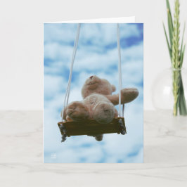 Tarjeta Festiva Beertje op schommel met bewolkte blauwe lucht.