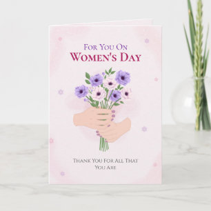 Tarjeta Festiva Día de la Mujer con manos sosteniendo ramo floral 