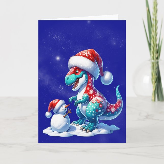 Tarjeta Festiva Dinosaur with santa hat building a snowman (Anverso)