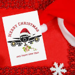 Tarjeta Festiva Divertido elfo lindo saltando en avión, Navidades<br><div class="desc">Divertido Elf Cute salta en avión, Navidades Ornamento de fotos. El diseño presenta un ilustracion minimalista de un gran avión coronado con un sombrero rojo de Santa. Se ve a un elfo lindo saltando del avión colgando en una cadena de luces de Navidades. El dorso de la tarjeta tiene un...</div>