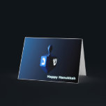 Tarjeta Festiva Dreidel azul brillante<br><div class="desc">Un dreidel modernista,  metálico y azul sobre un fondo oscuro y nocturno. Dos de las letras hebreas encontradas en un dreidel,  una monja y un shin,  brillan brillantemente. El texto que dice "Feliz Hanukkah" también aparece en azul brillante y blanco.</div>