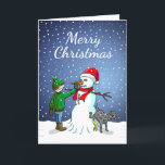 Tarjeta Festiva Edificio Snowman<br><div class="desc">El niño ha construido un muñeco de nieve en el que su perro se para y orina mientras el niño le da al hombre de nieve una nariz de zanahoria.</div>