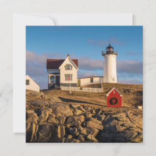 Tarjeta Festiva Faro al atardecer con decoraciones navideñas