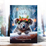 Tarjeta Festiva Koala Bear Snowy Winter Forest Navidades alegres<br><div class="desc">Esta adorable tarjeta de saludo de vacaciones incluye un lindo ilustracion del oso Koala con una corona festividad de flores de invierno, flor, pino y bayas, con copos de nieve cayendo suavemente sobre un fondo del bosque de bosques de invierno nevado. ¡El pequeño Oso de Koala está mirando sobre el...</div>