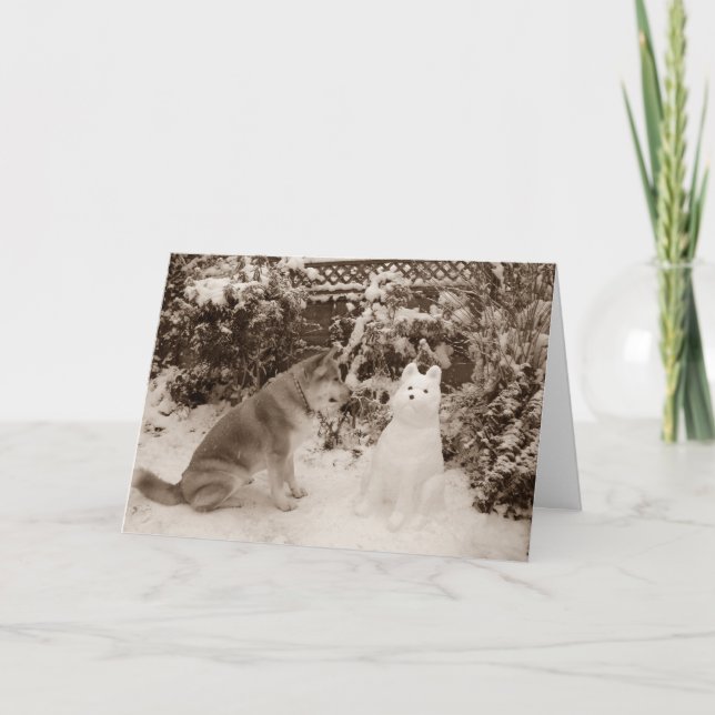 Tarjeta Festiva linda akita sentada en la nieve con perro de muñec (Anverso)