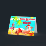 Tarjeta Festiva Miami Merry Christmas Santa y Flamingo Beach<br><div class="desc">Esta tarjeta de felicitación de navidad de Feliz Navidad incluye Santa Cláusula en Miami Beach. Se está relajando disfrutando del sol, las palmeras, su pipa y un gracioso flamenco rosa usando un sombrero de Santa y corona. Saludos internos ~ "Los deseos más cálidos de nuestro paraíso de vacaciones a los...</div>