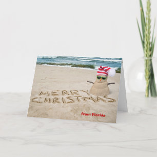 Tarjeta Festiva Muñeco de nieve de arena en la playa con océano