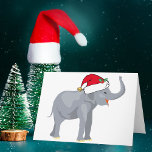 Tarjeta Festiva Navidades amables elefante blanco en Santa Hat<br><div class="desc">Los animales vacacionales son mi parte favorita de los Navidades. Un bello elefante gris con un sombrero rojo de Papá Noel y que se ve feliz. Esto me llena del espíritu Navidad. Personalizar con el nombre de su destinatario de regalo para personalizar el presente.</div>