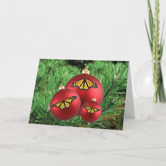 Tarjeta Festiva Navidades cargan monarcas en ornamentos rojos