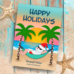 Tarjeta Festiva Navidades del Tropical Beach Santa Hammock<br><div class="desc">La tarjeta de Navidades tropicales y costeros ofrece a Santa relajarse en una hamaca en la playa, disfrutar de las olas del océano y de una colorida puesta de sol y palmeras festivas adornadas con luces de cuerda. El saludo de arriba dice "Felices Fiestas" en azul marino. El saludo en...</div>