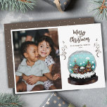 Tarjeta Festiva Navidades fotográficos de Glass Snowball Winter Vi<br><div class="desc">Festive Glass Snowball Winter Village Foto Festividad Tarjeta navideña navideña Festividad. Casas de cuento de hadas en invierno con nieve y hermosos copos de nieve. Plantas de escalada marrones. Un deseo de Feliz Navidad en un guión de moda. Puede cambiar cualquier texto y agregar su foto.</div>