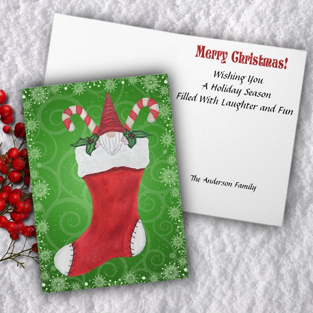 Tarjeta Festiva Navidades se enganchan canes de caña en rojo (Gnome inside red Christmas stocking with holly leaves candy canes on green swirled Greeting Card.)
