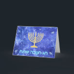 Tarjeta Festiva Nevada Menorah de Jánuca<br><div class="desc">Un menorah y un "Chag que brillan intensamente Chanukkah Sameach" de Jánuca del oro (Jánuca feliz) en brillar intensamente texto azul y blanco sobrepuesto en una imagen azul y blanca del fractal evocadora de copos de nieve en una tormenta.</div>